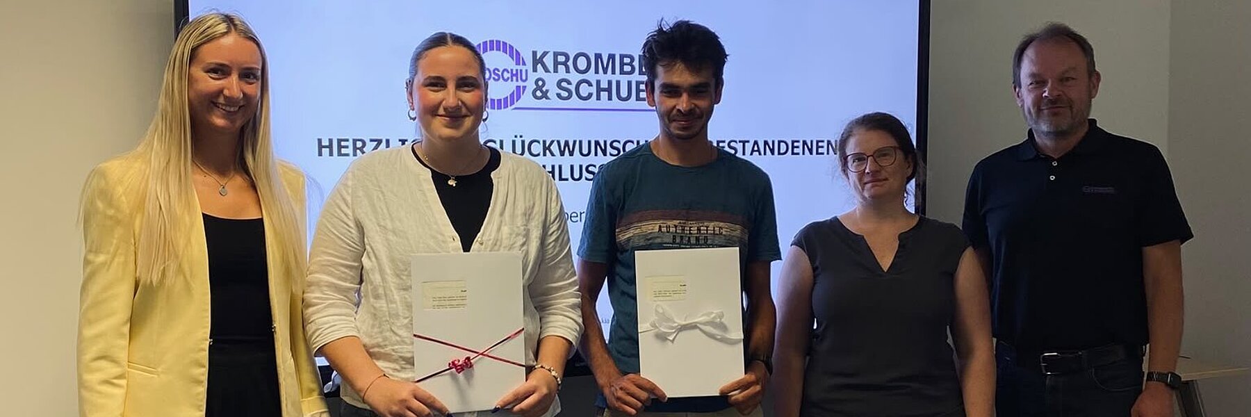 Die Absolventinnen und Absolventen gemeinsam mit ihren Ausbildern und Geschenken.